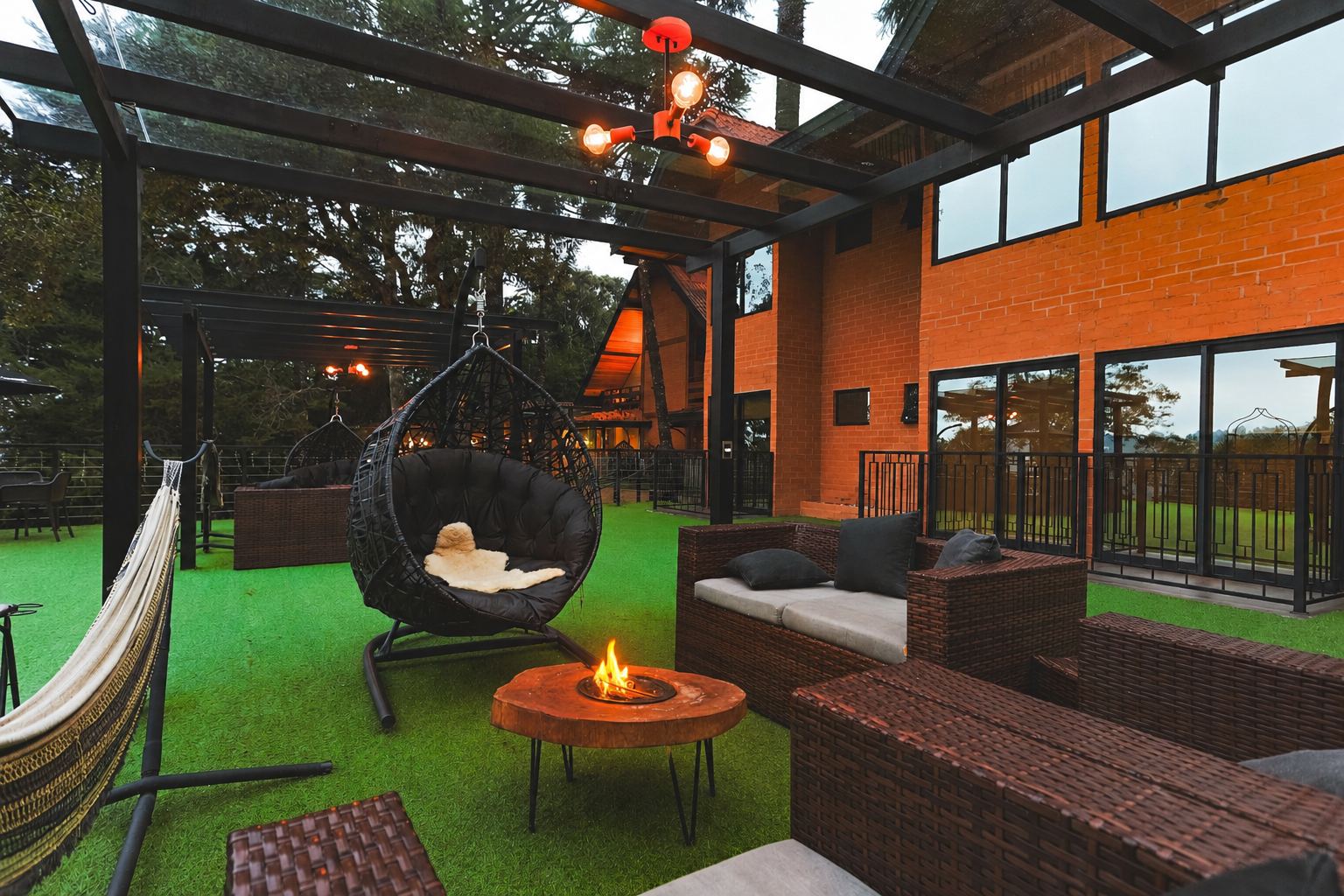 Lounge externo com balanços e fogo de chão