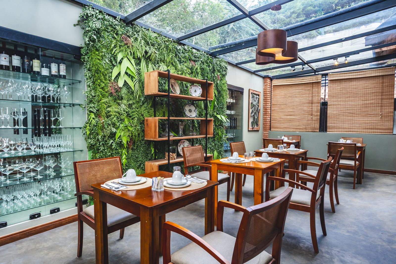 Salão do café da manhã com teto de vidro e jardim vertical